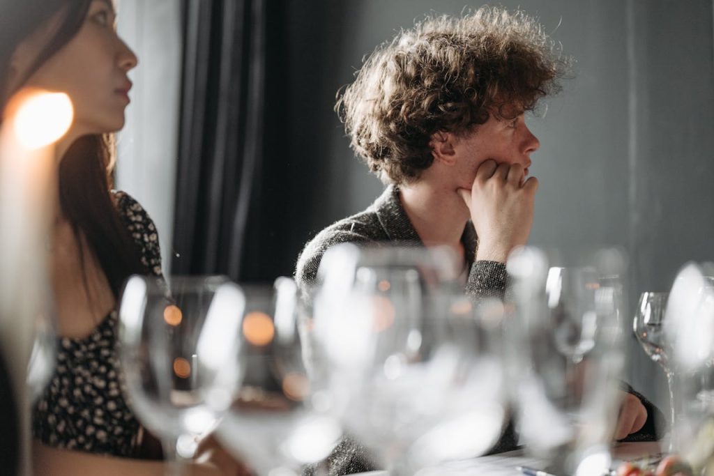 Group of adults attending a wine tasting event indoors with glassware.